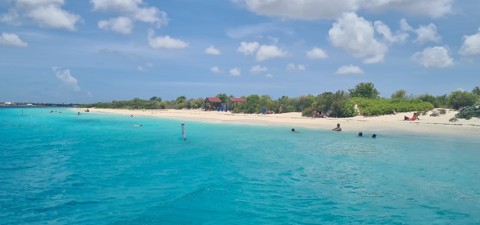 Mensen kijken vanaf een boot naar het zandstrand van No Name Beach